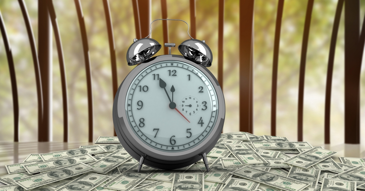 clock with banknotes wooden table 1200x628 2